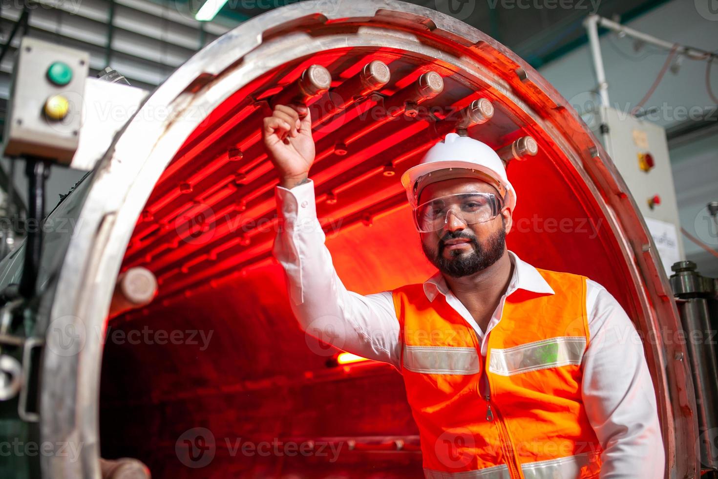 professional technician engineer with safety hard hat working to maintenance construction equipment in industrial factory, worker is checking or repair the machine. photo