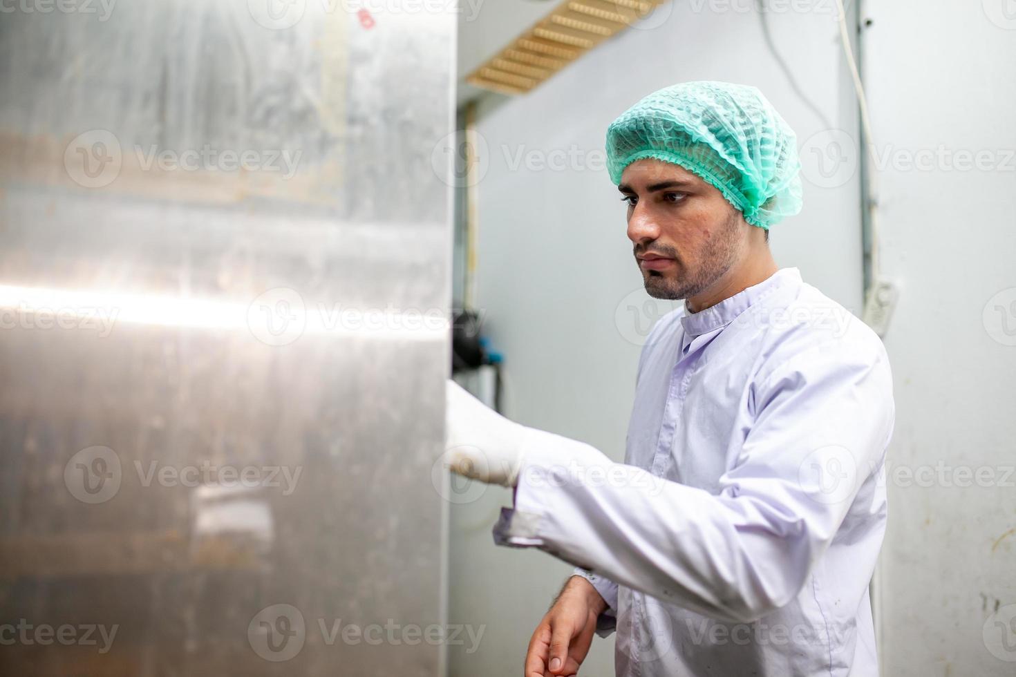 worker is control operating  machine and turn on switch on the production line in the beverage factory. photo