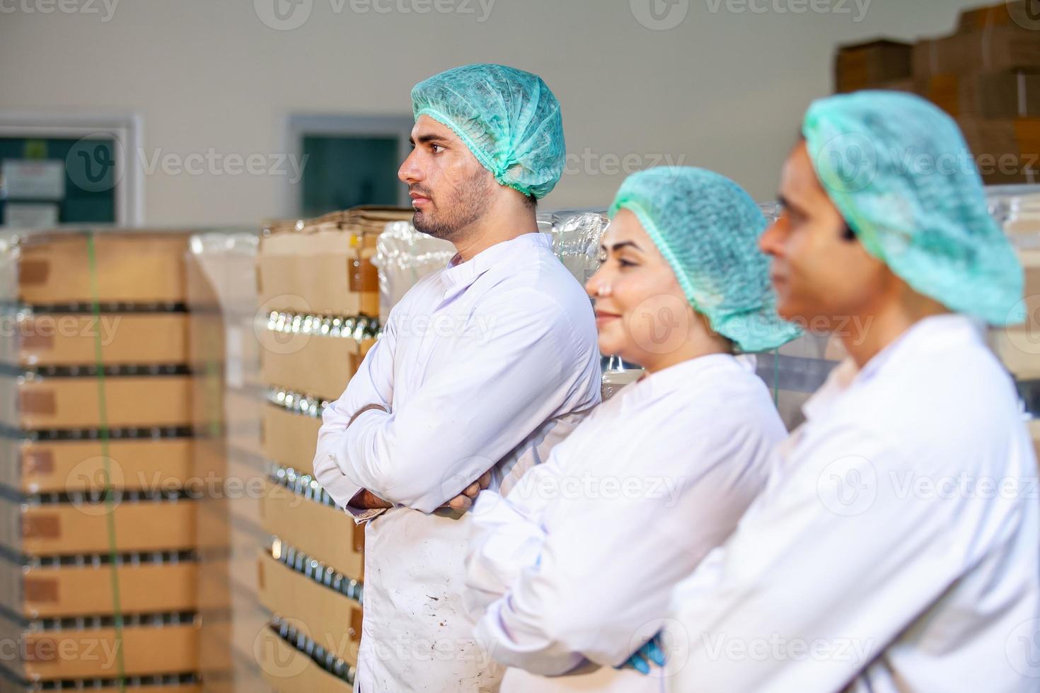 worker team on the production line in the beverage factory. Manufacturer checks quality of food industry. photo