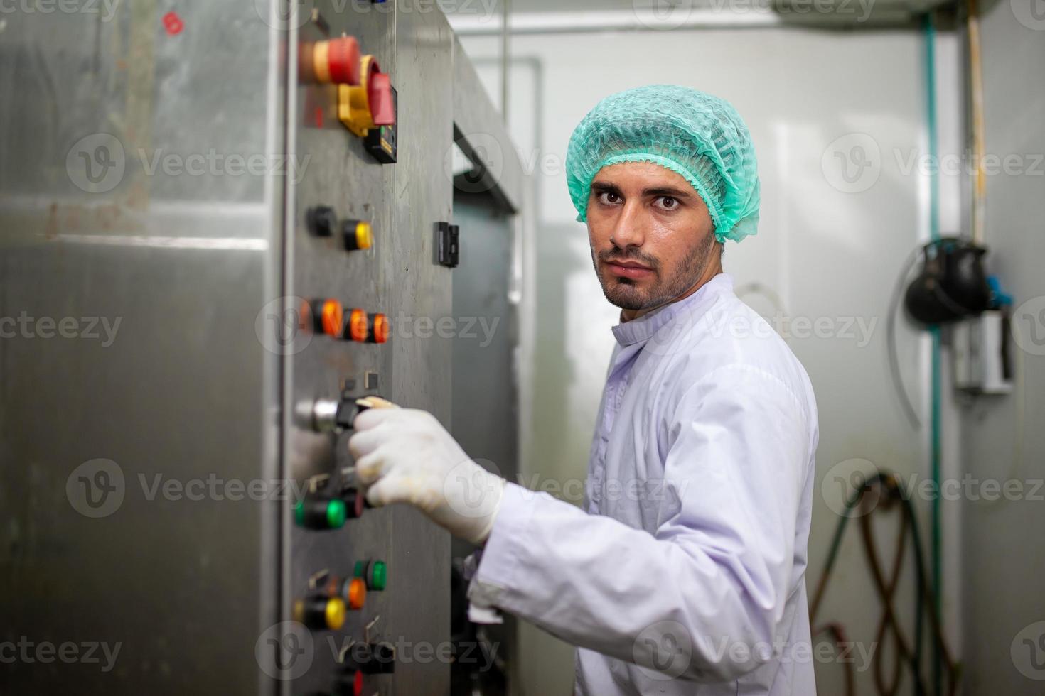 worker is control operating  machine and turn on switch on the production line in the beverage factory. photo