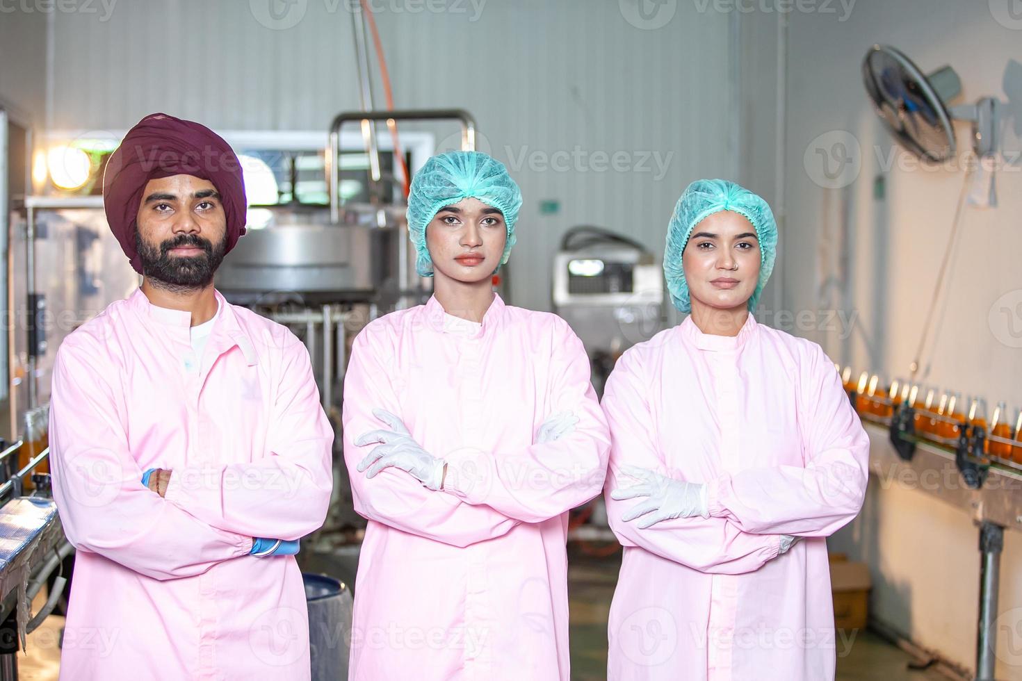 Group of Asian worker with clipboard is checking product bottles of fruit juice on the production line in the beverage factory. Manufacturer checks quality of food industry. photo