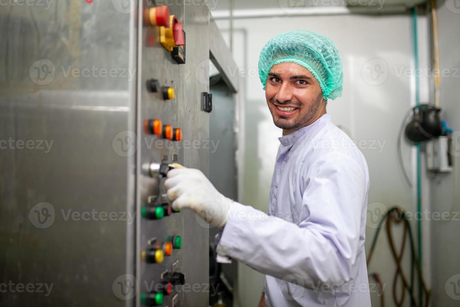 worker is control operating  machine and turn on switch on the production line in the beverage factory. photo