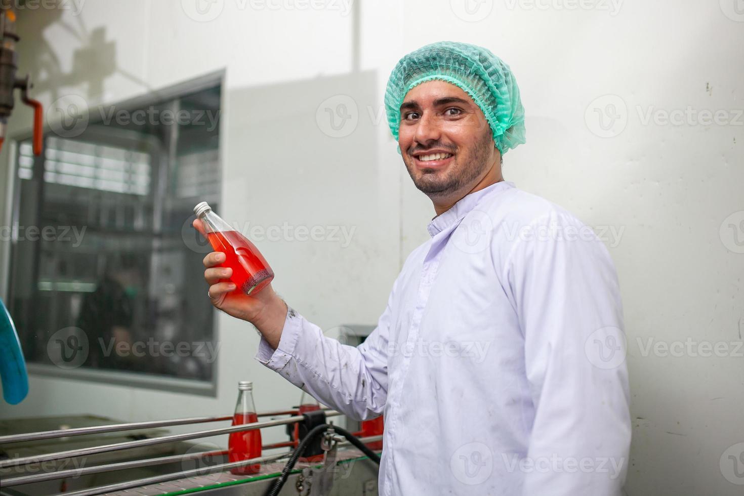 Asian woman worker is checking product bottles of fruit juice on the production line in the beverage factory. Manufacturer checks quality of food industry. photo