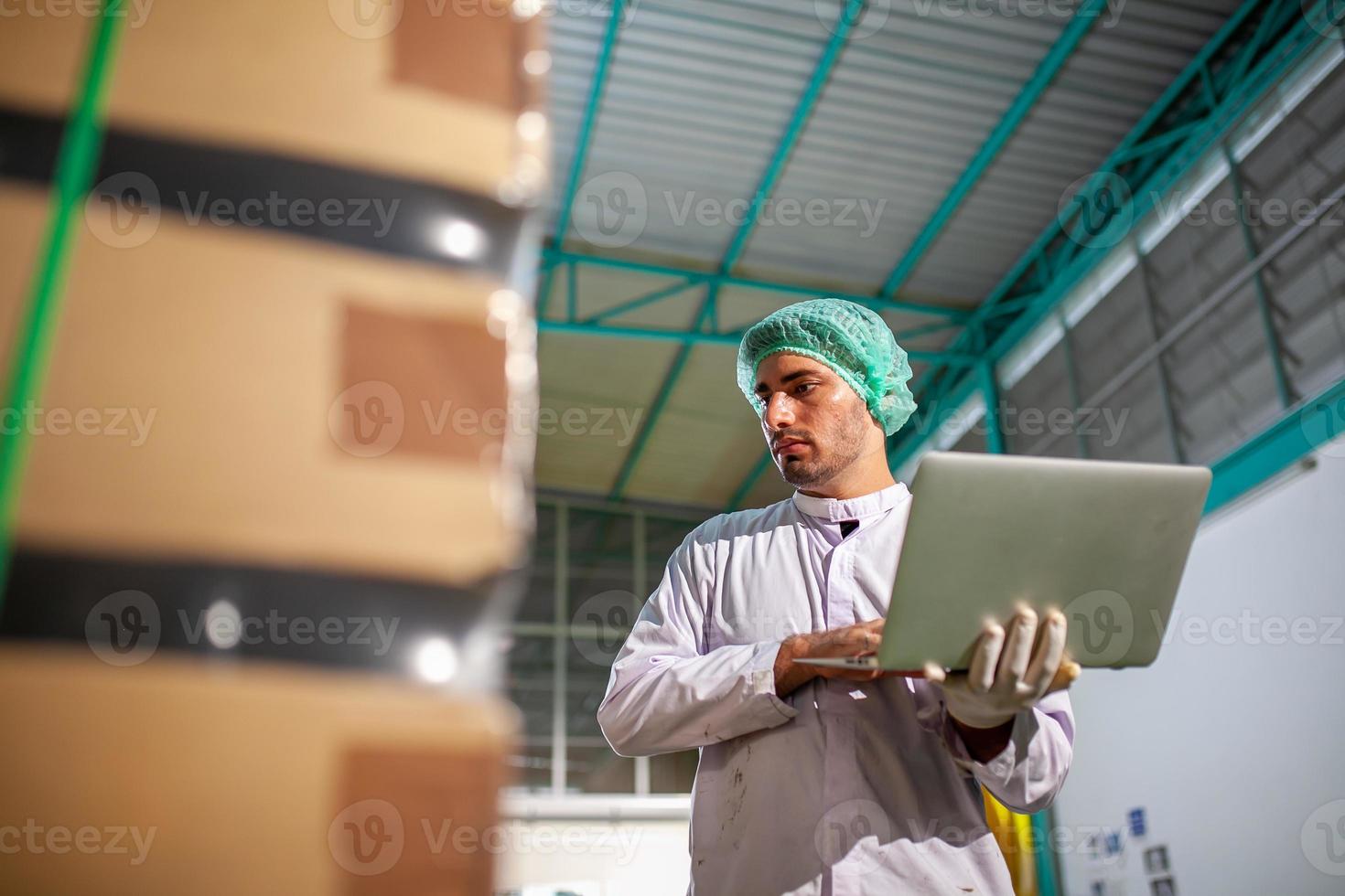 worker with laptop is checking product on the production line in the beverage factory. Manufacturer checks quality of food industry. photo