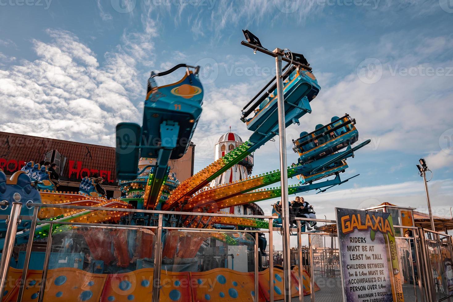 Holiday makers on roller coasters and rides at the amusement park on Brighton photo