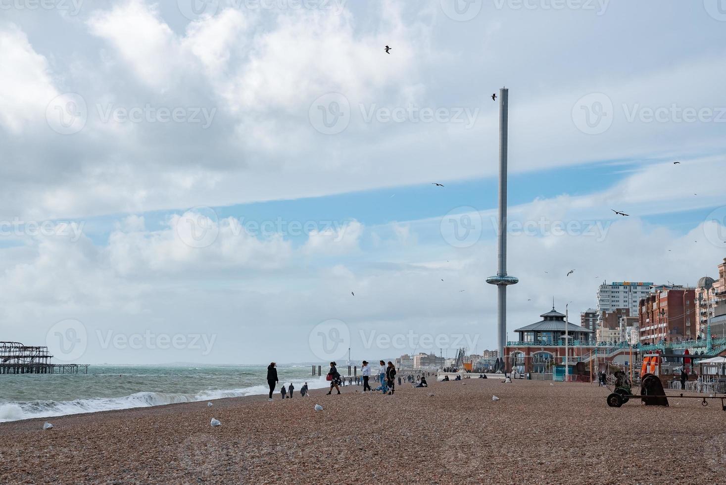 People walking down the promenade near the beach in Brighton. photo