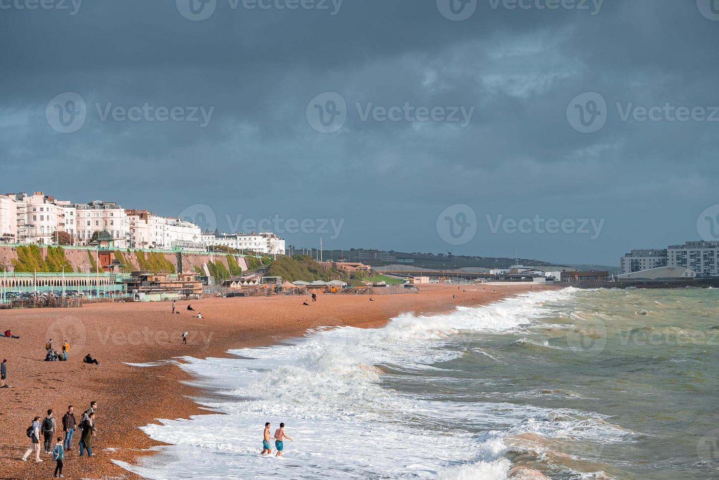 People walking down the promenade near the beach in Brighton. photo