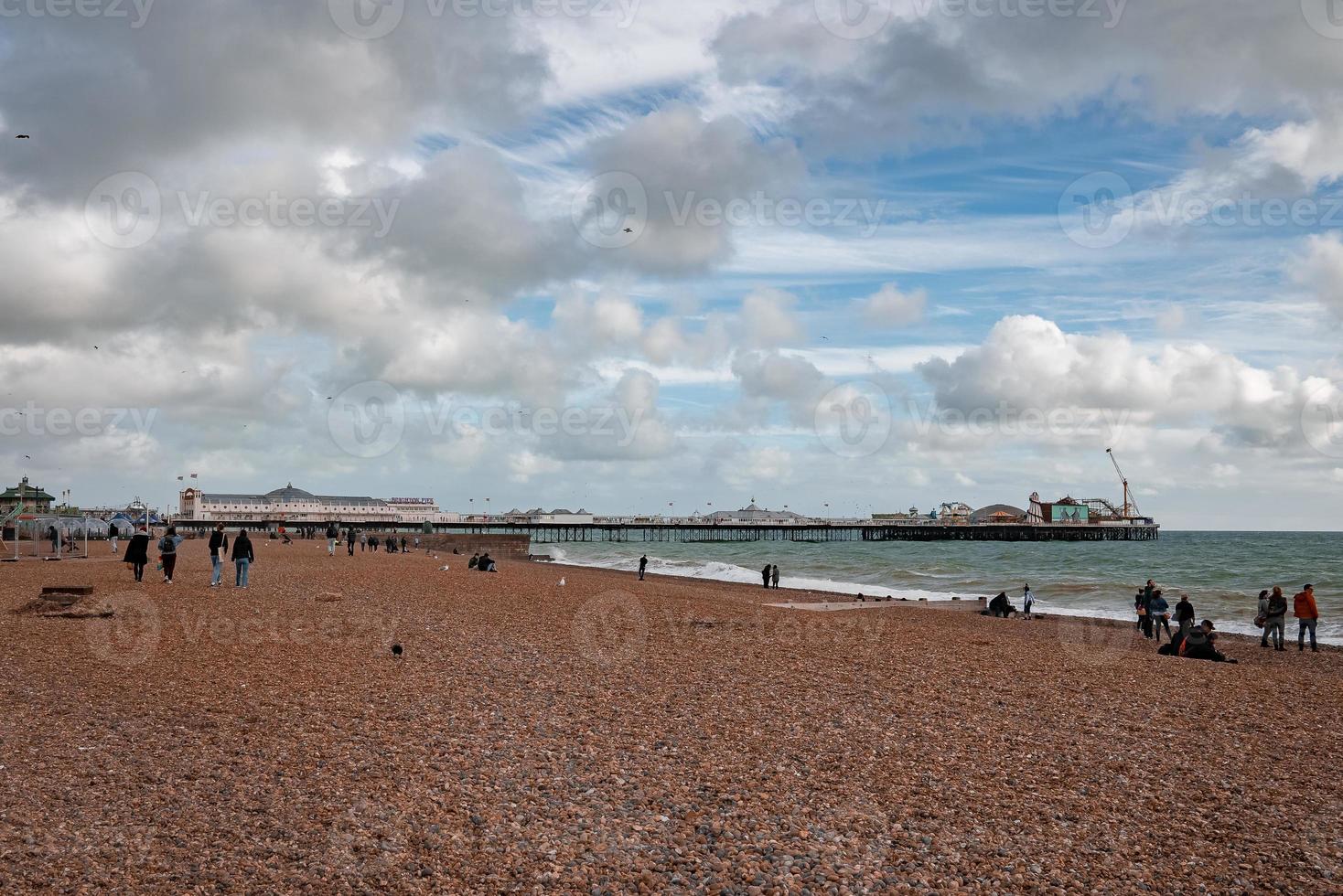 People walking down the promenade near the beach in Brighton. photo