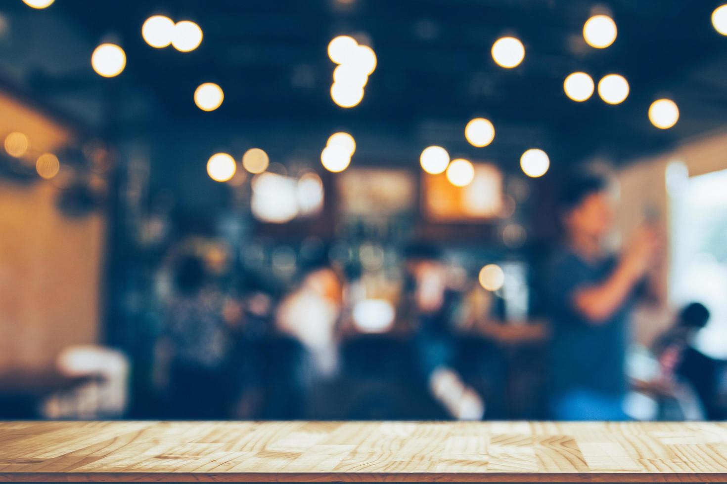 Image of wooden table in front of abstract blurred restaurant lights background photo
