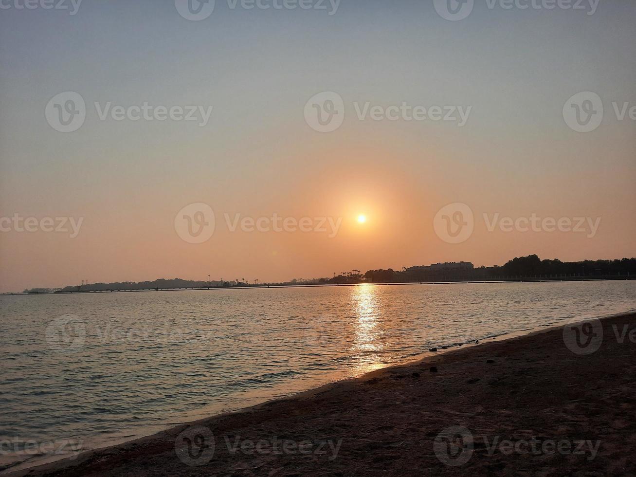 una hermosa tarde y una colorida puesta de sol en la playa de jeddah. foto