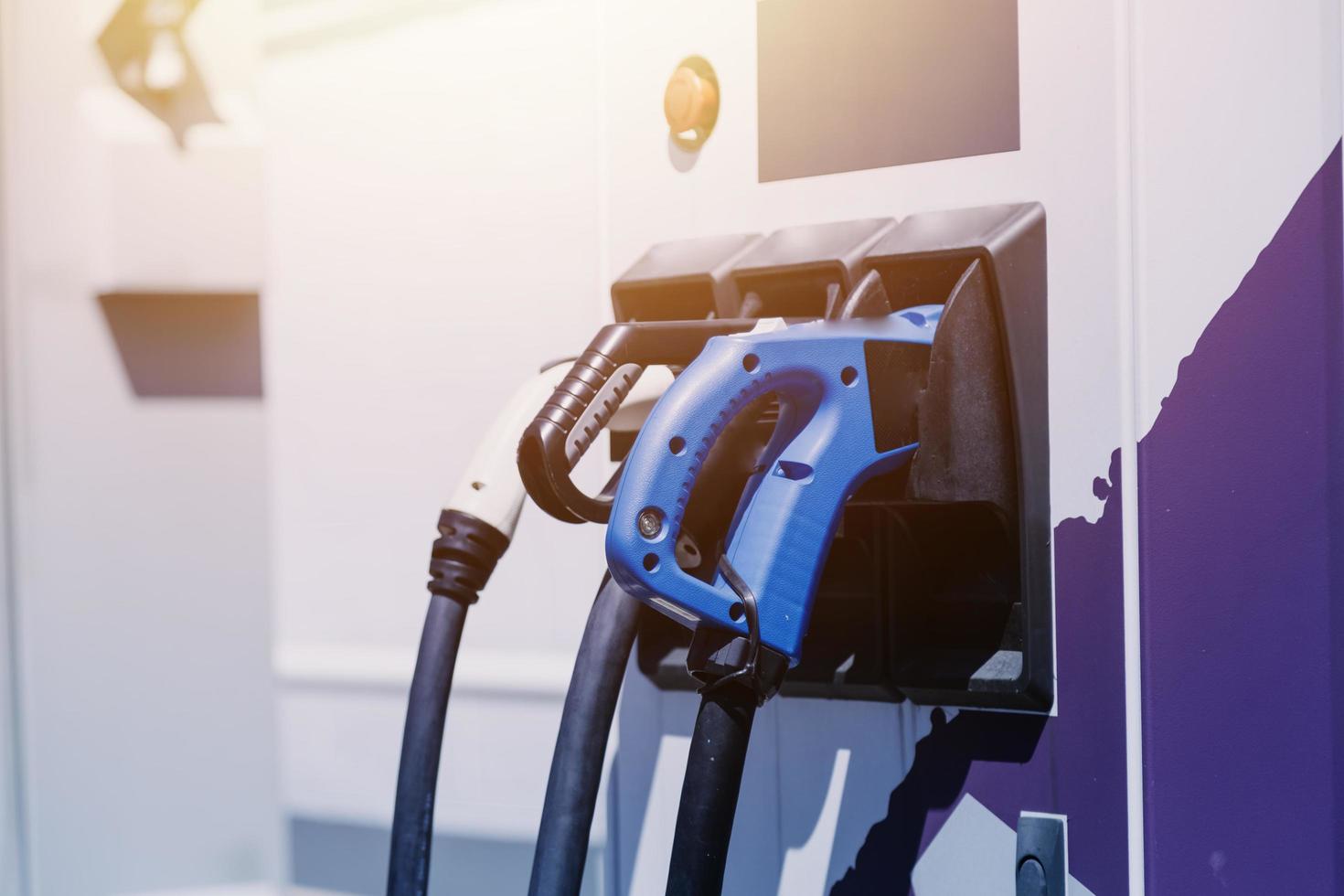 Hand plugging in a charger in an electric car socket.Electric car or ev is charging at station photo