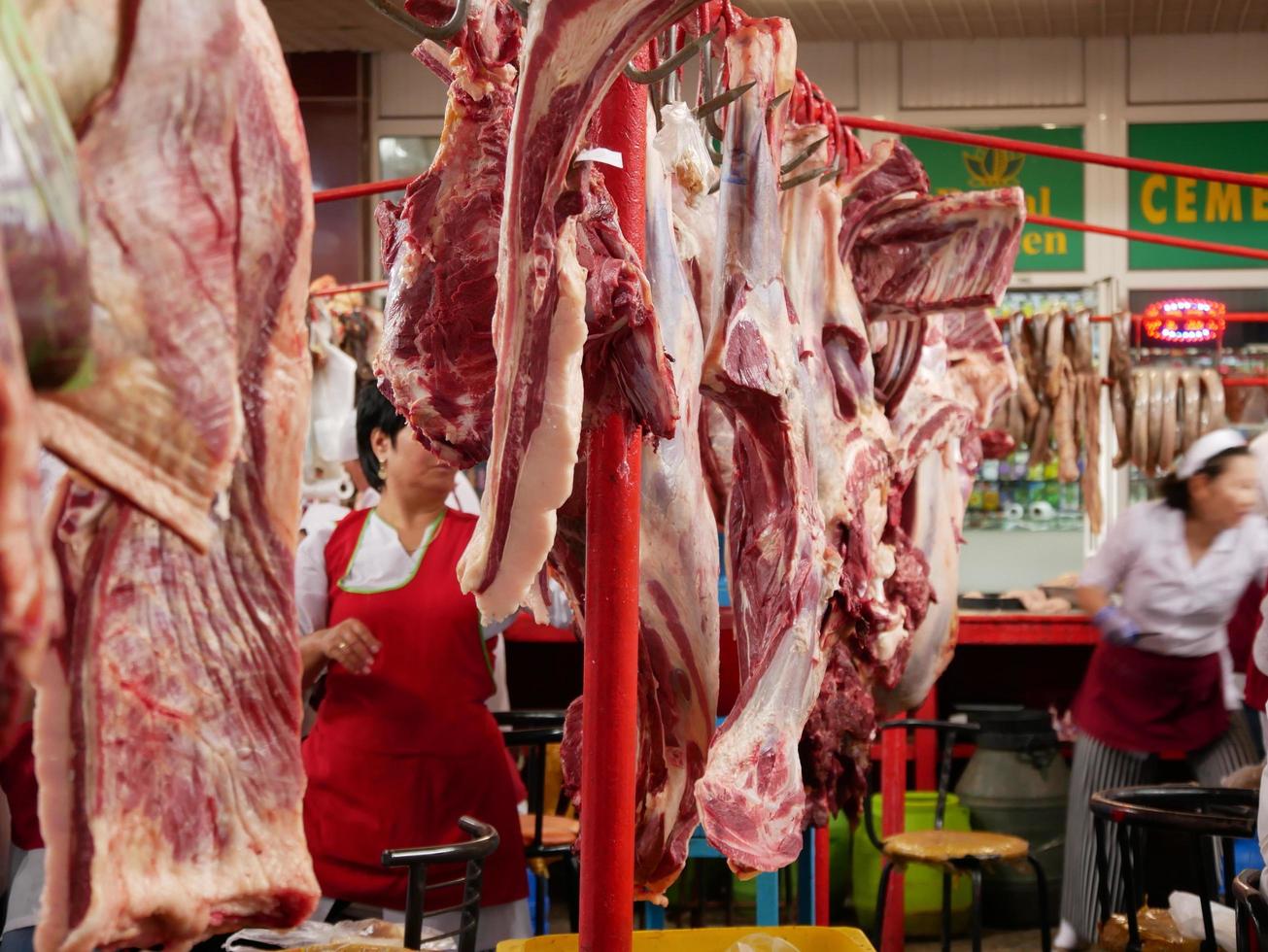 almaty, kazakhstan, 2019 - personas en la sección de carne del famoso bazar verde de almaty, kazakhstan, con productos en exhibición. foto