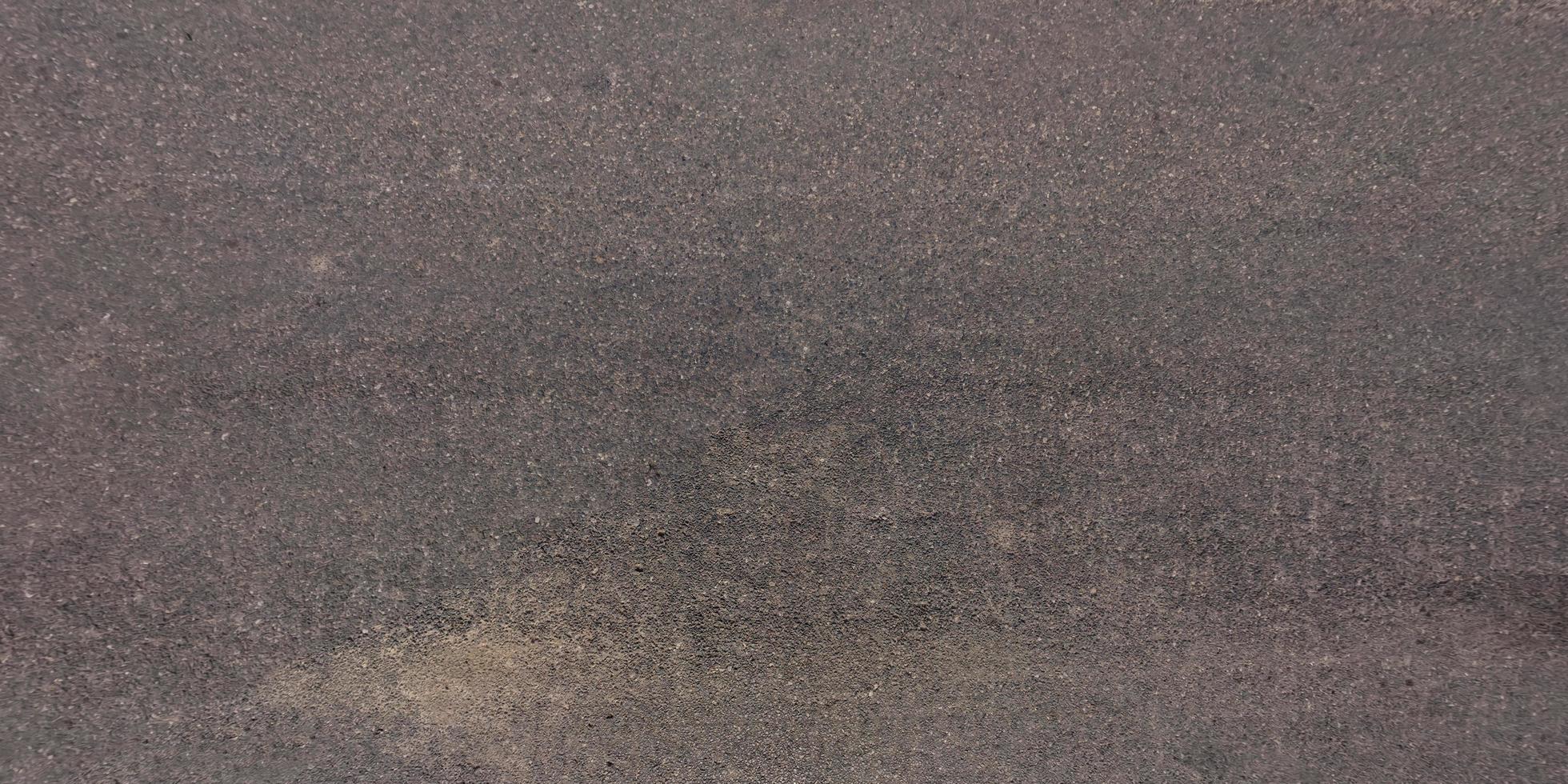 view from above on surface texture of old asphalt road with cracks photo