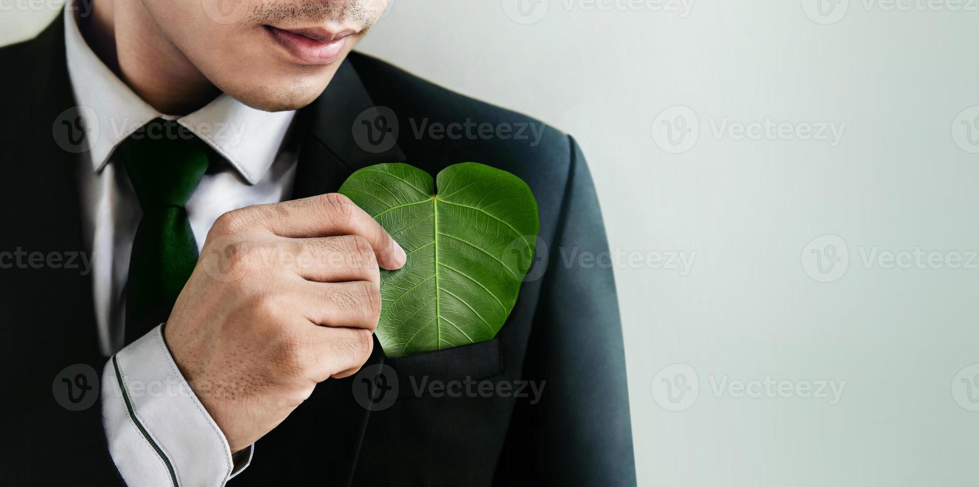 Green Energy, Renewable and Sustainable Resources. ESG, Ecology Care Concept. Environmental, social and corporate governance. Businessman insert a Heart Shape Green Leaf in Pocket photo