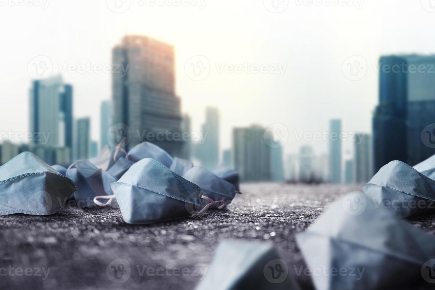 Used Medical Mask on ground. Challenging of Business during Coronavirus. Low angle View. blurred City Town as background photo