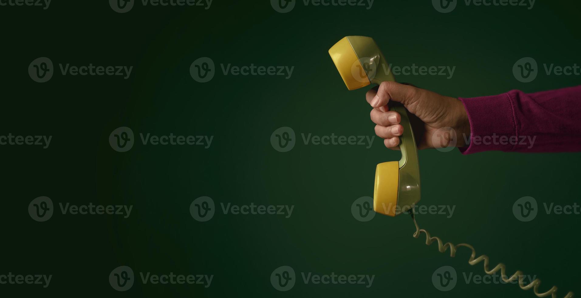 Retro Telephone. Hand holding a Handset. Communication Concept. Old Classic item from 1980-1990. Vintage colour Tone. Horizontal Banner Size photo