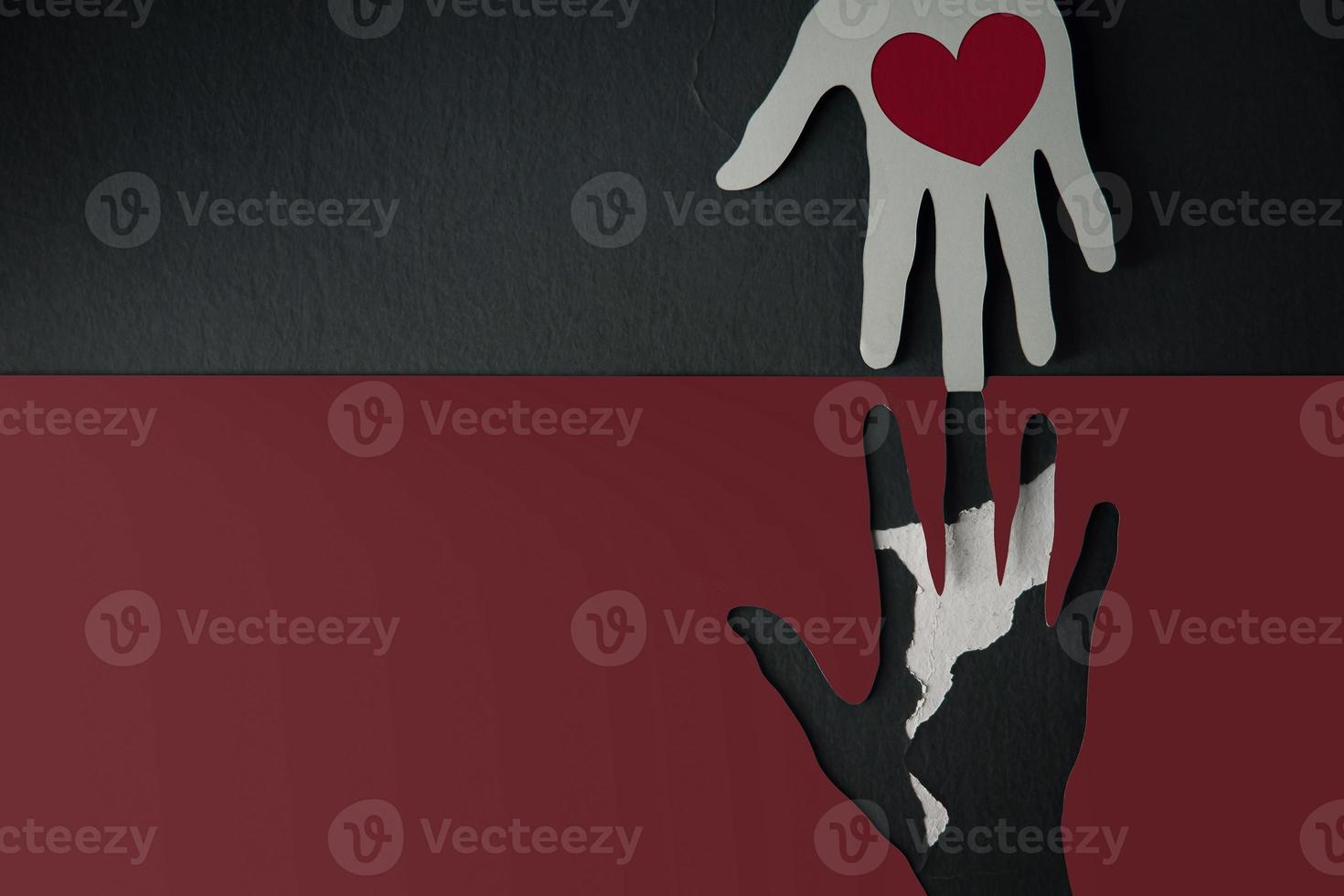 Donation Concept. Help, Care, Love, Support or Partnership. Paper Cut as Hands Shape hanging on the wall. look like the top one with a Red Heart trying to help the one below photo