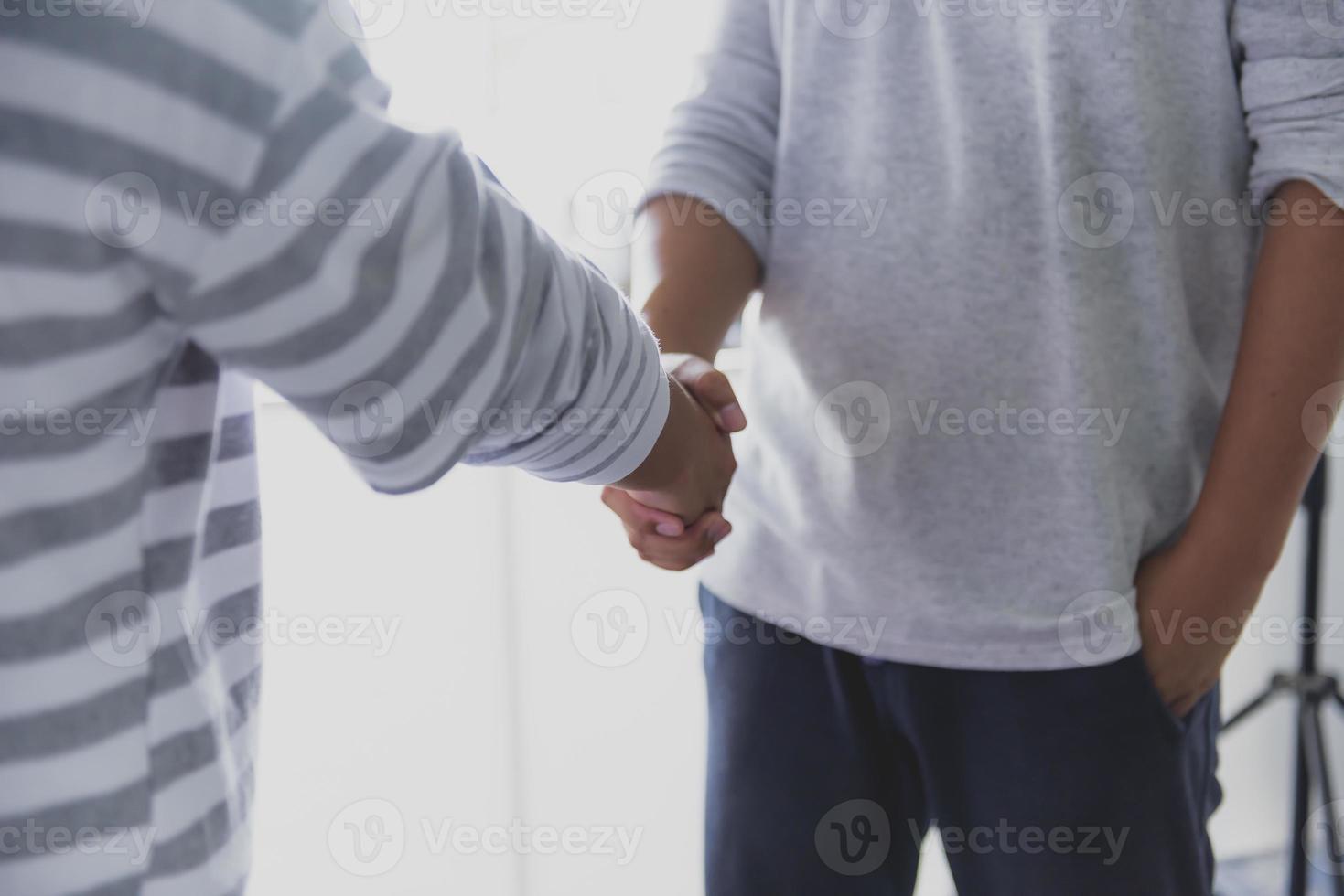 dos hombres de negocios confiados se dieron la mano durante las reuniones de oficina. foto