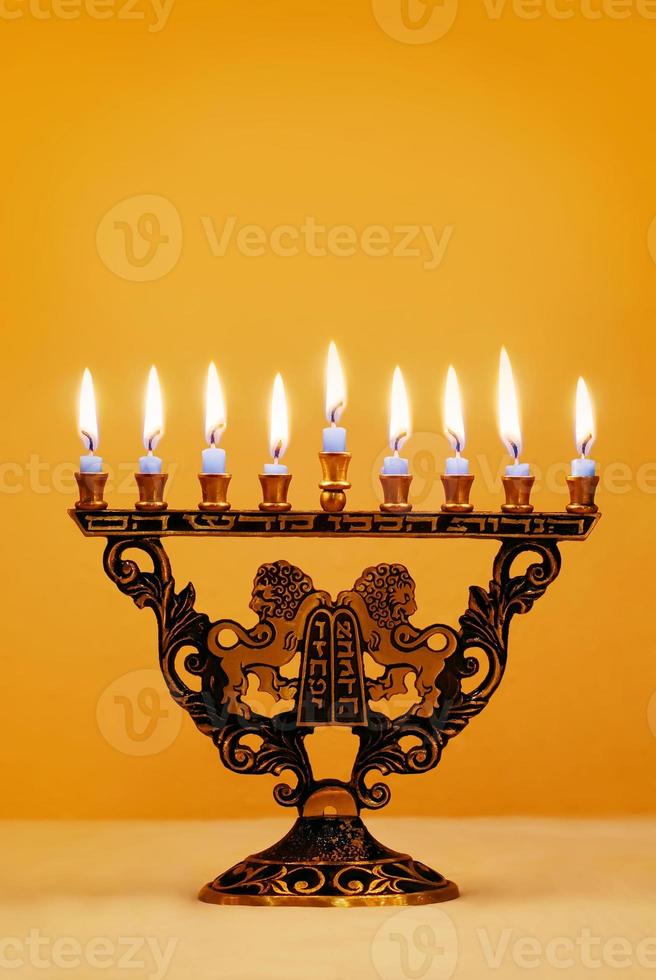 velas de hanukkah brillantemente iluminadas en la menorá de león foto