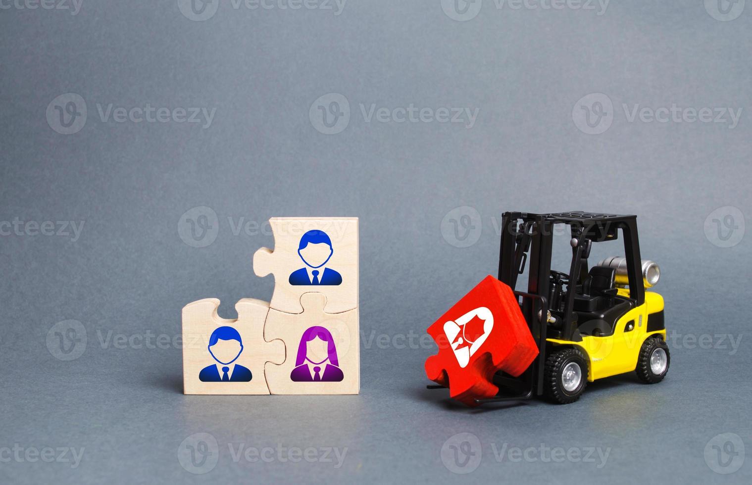 A forklift truck carries a red puzzle to the unfinished assembly of business team. Search, recruitment staff, hiring leader. Creating an efficient and productive business unit. Leadership and teamwork photo