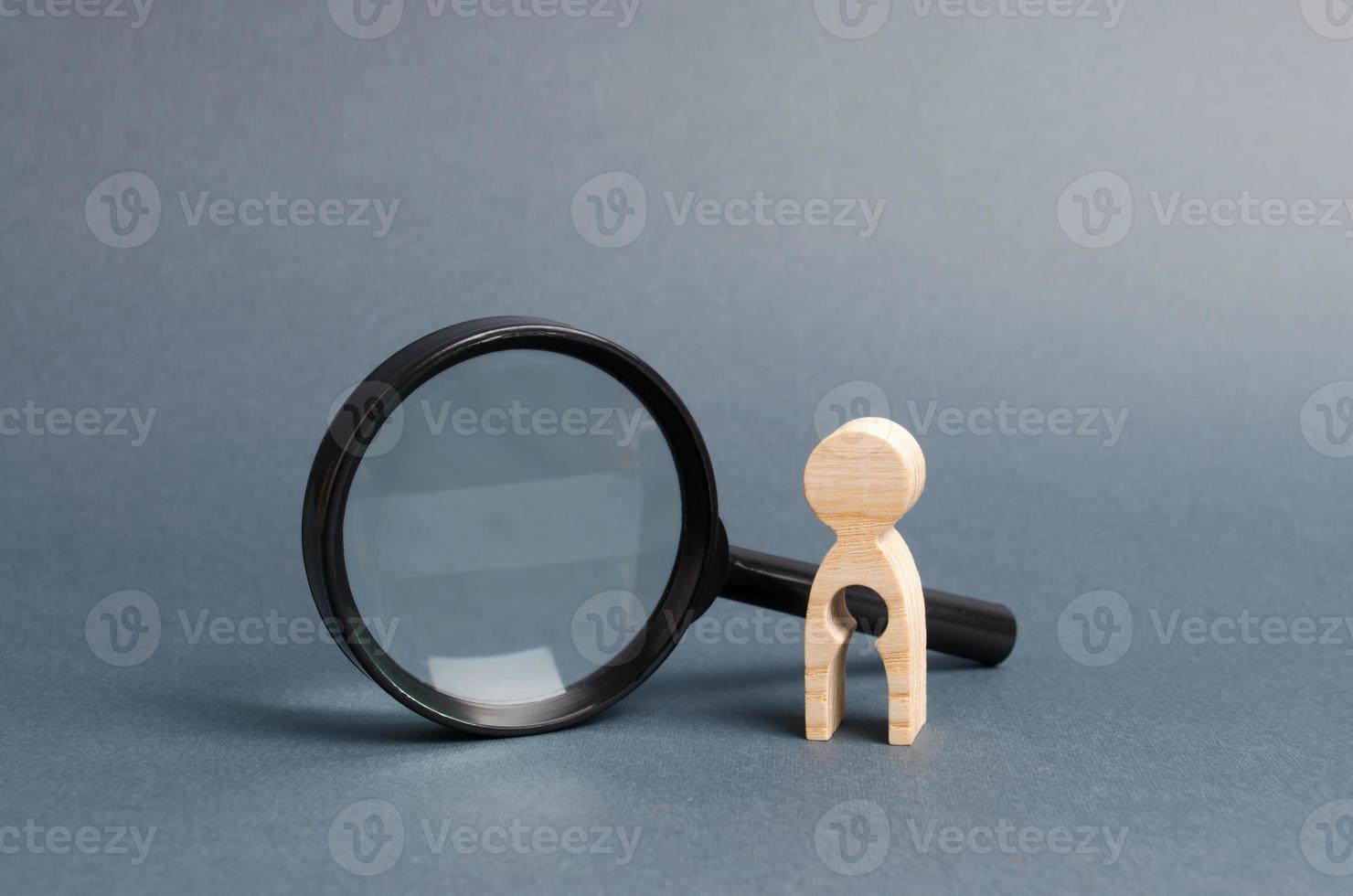 A wooden figure with a baby-shaped void stands near a magnifying glass. concept of infertility and women and the inability to have children. Abbort, the loss of a child. Treatment and Prevention photo