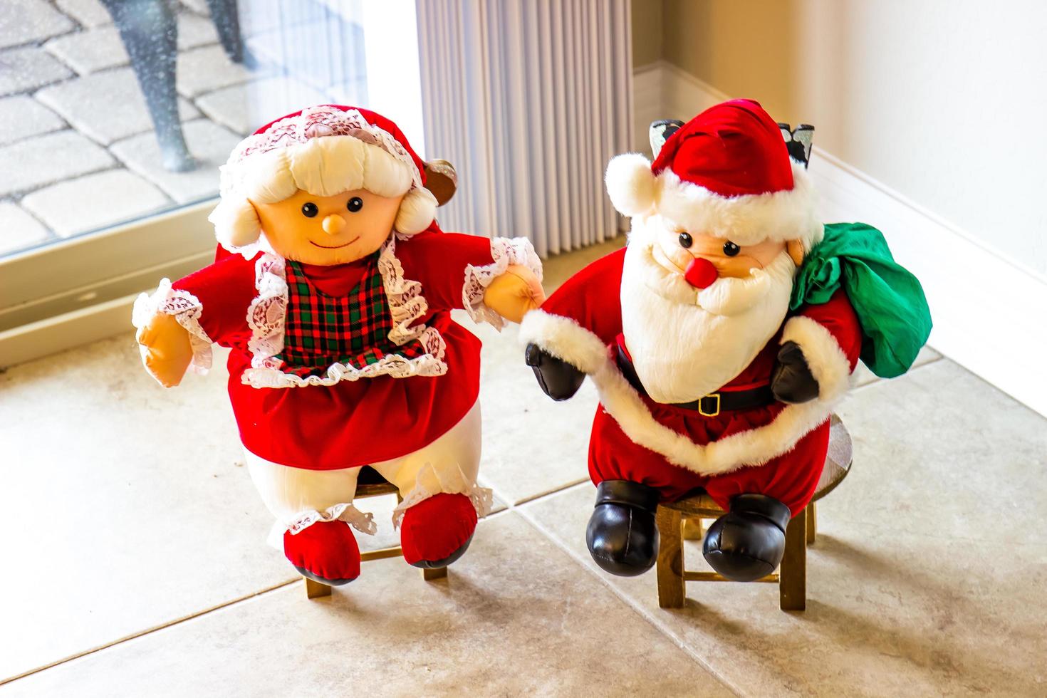 mini señor y señora santa claus en pequeños taburetes foto