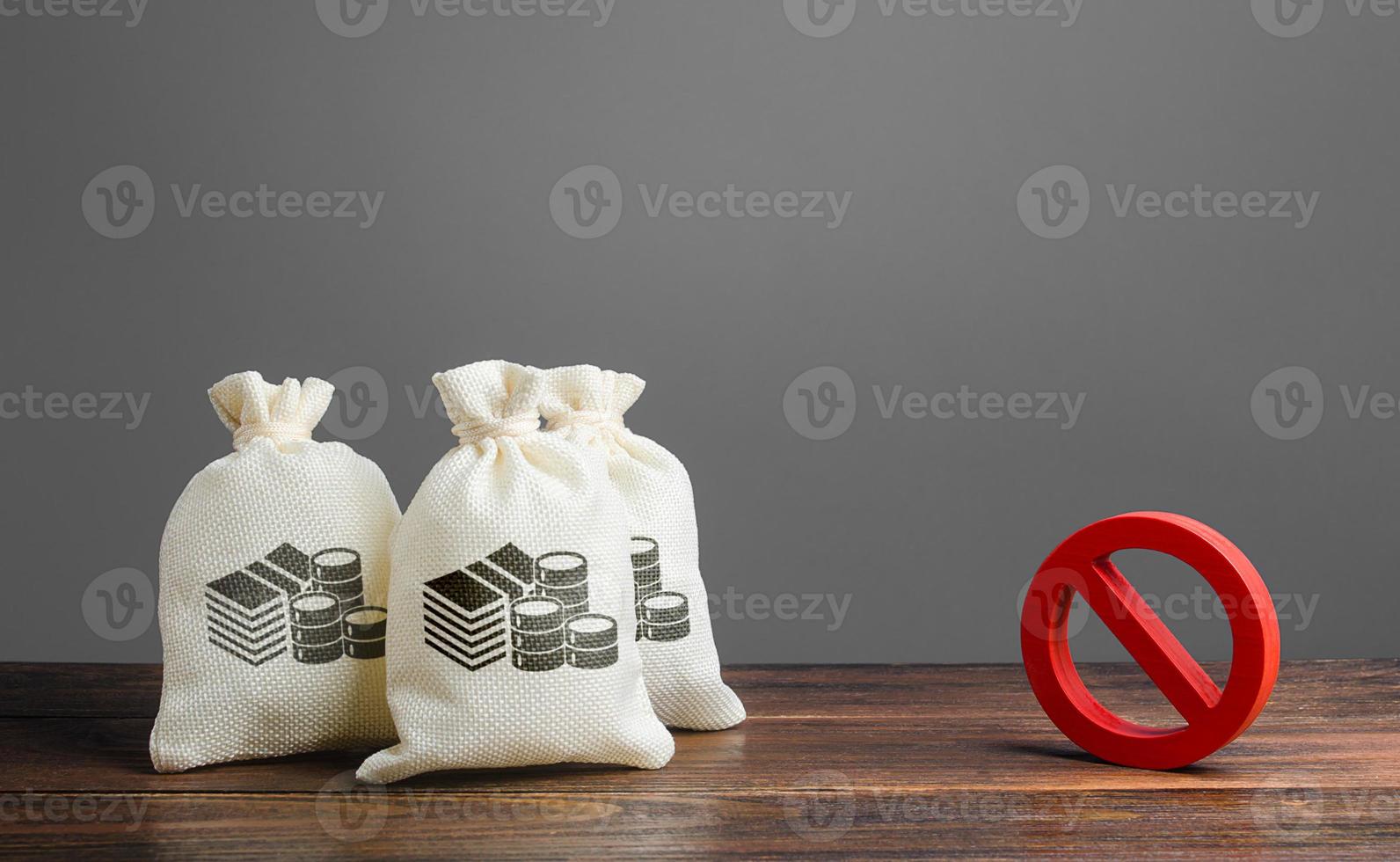 Money bags and red prohibition sign no. Restrictions on the export of capital, Economic pressure and sanctions. Lack of investment and inflow of finance. Regulatory laws in the financial sector. photo