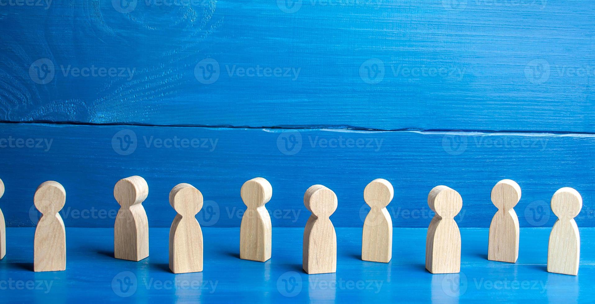 Figures of people on a blue background. Maintaining a safe distance in queue. New normal. Society concept. Communication. Population and citizens. Faceless persons. Detachment and loneliness photo