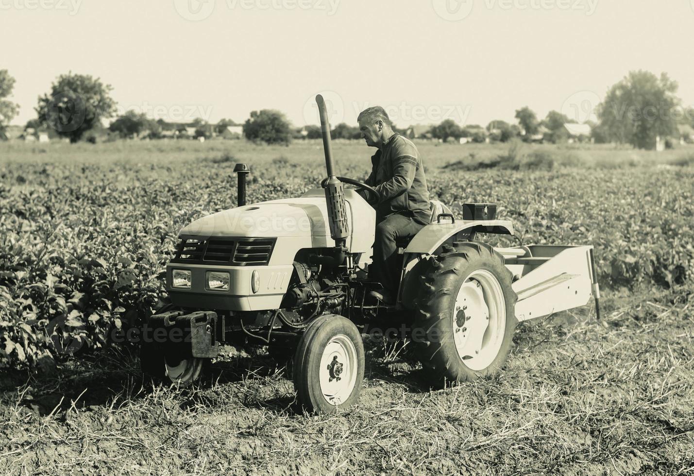 A farmer on a tractor is working on a farm field. Agroindustry and agribusiness. Agricultural sector of the economy. Plant food production. Machinery and equipment. photo