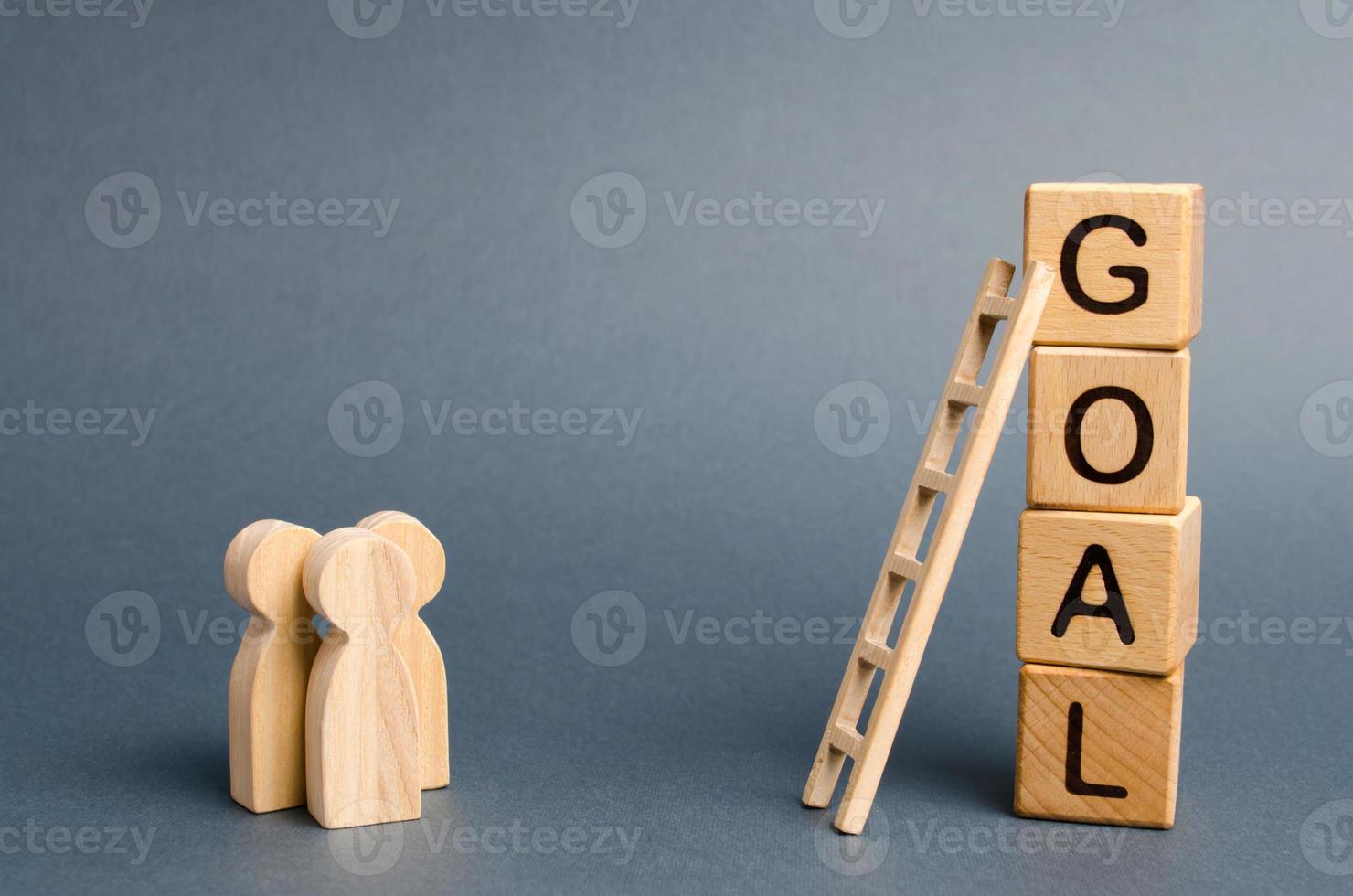 Three people are standing near the tower of cubes with the word goal. Evaluation of options and means to conquer the summit and achieve the goal. Business concept. cooperation and teamwork photo