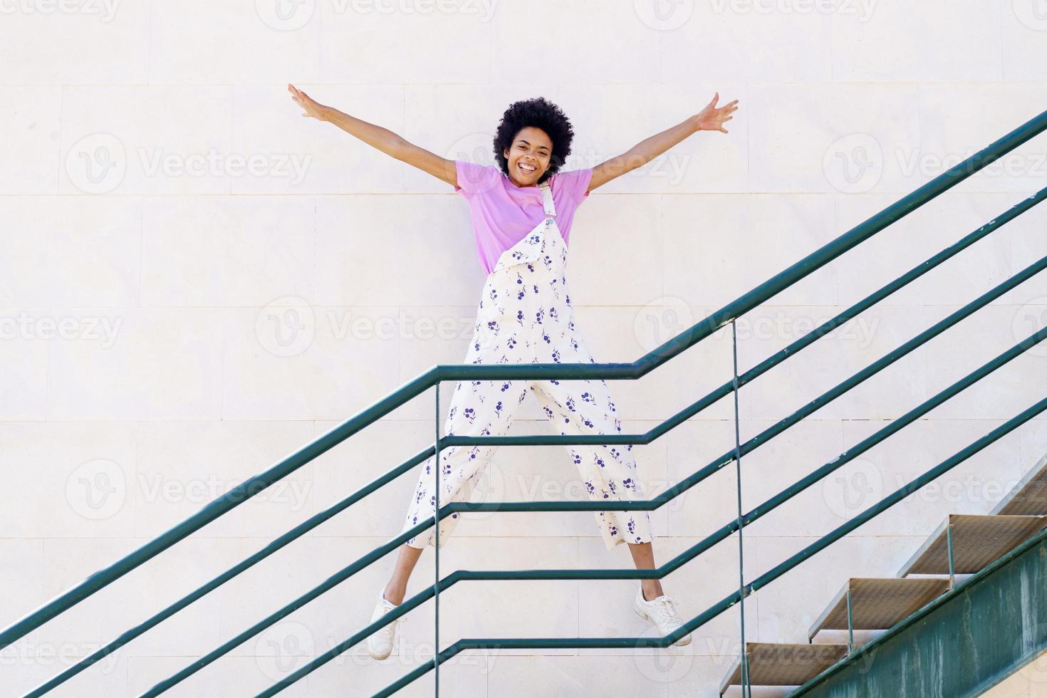 Cheerful black woman jumping on stairway photo