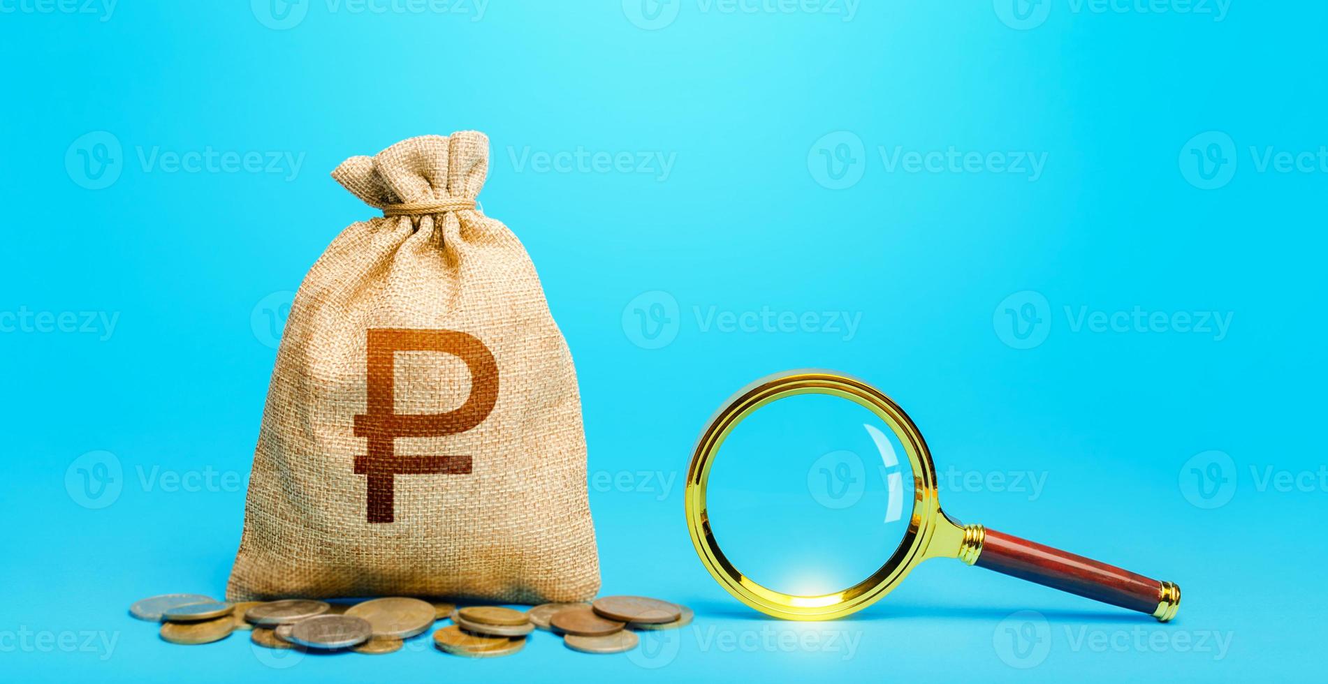 Russian ruble money bag and magnifying glass. Revising the budget to save money. Financial audit control. Most favorable conditions for deposits. Origin of capital funds. Search for financing. photo