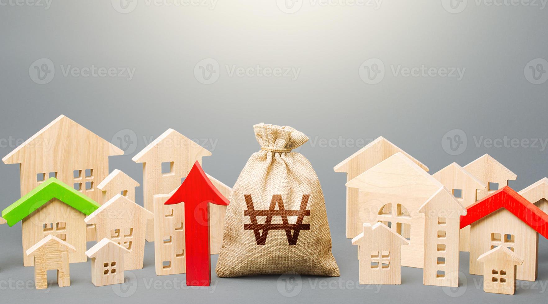 South korean won money bag and a city of house figures and red up arrow. Rent growth. Recovery and growth in property prices, high demand. Investments. Increase in revenues to municipal budget. photo