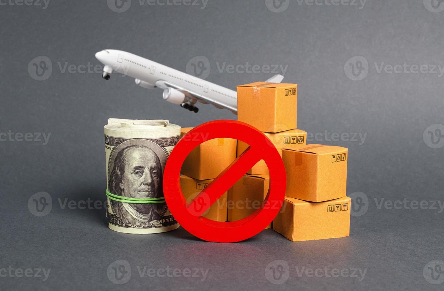 The prohibition sign NO blocks, bundle of dollars money and boxes with a airplane. Embargo, trade wars. Restriction on importation goods, proprietary for business. Sanctions and economic restrictions photo