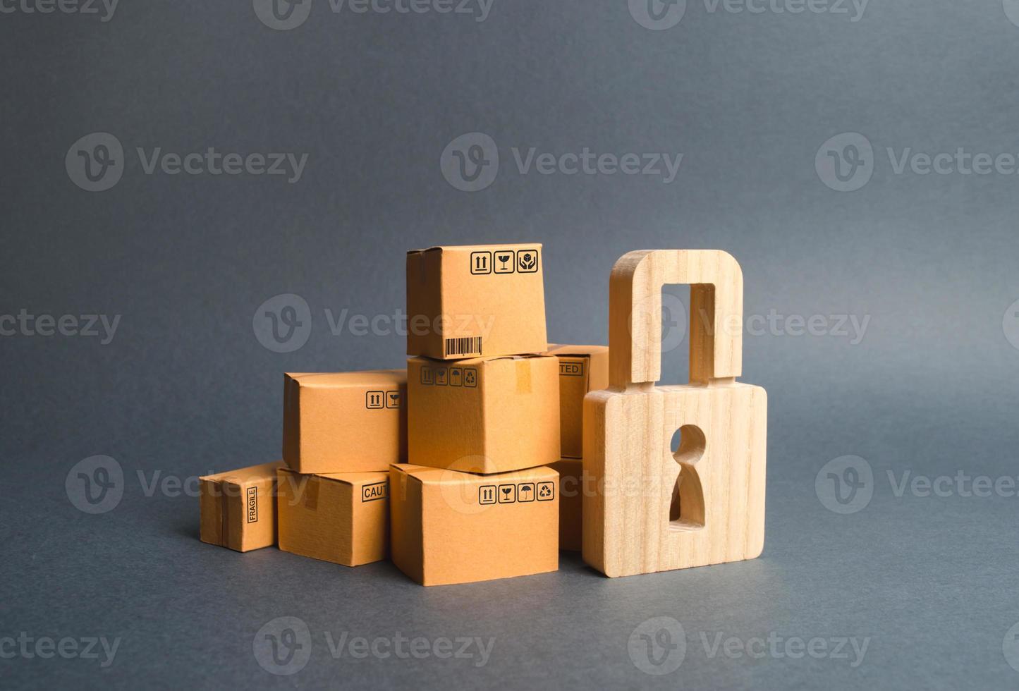 A pile of cardboard boxes and a wooden padlock. concept of insurance purchases. Providing warranty on purchased products. Consumer rights Protection. cargo arrest customs clearance. ban on the import. photo