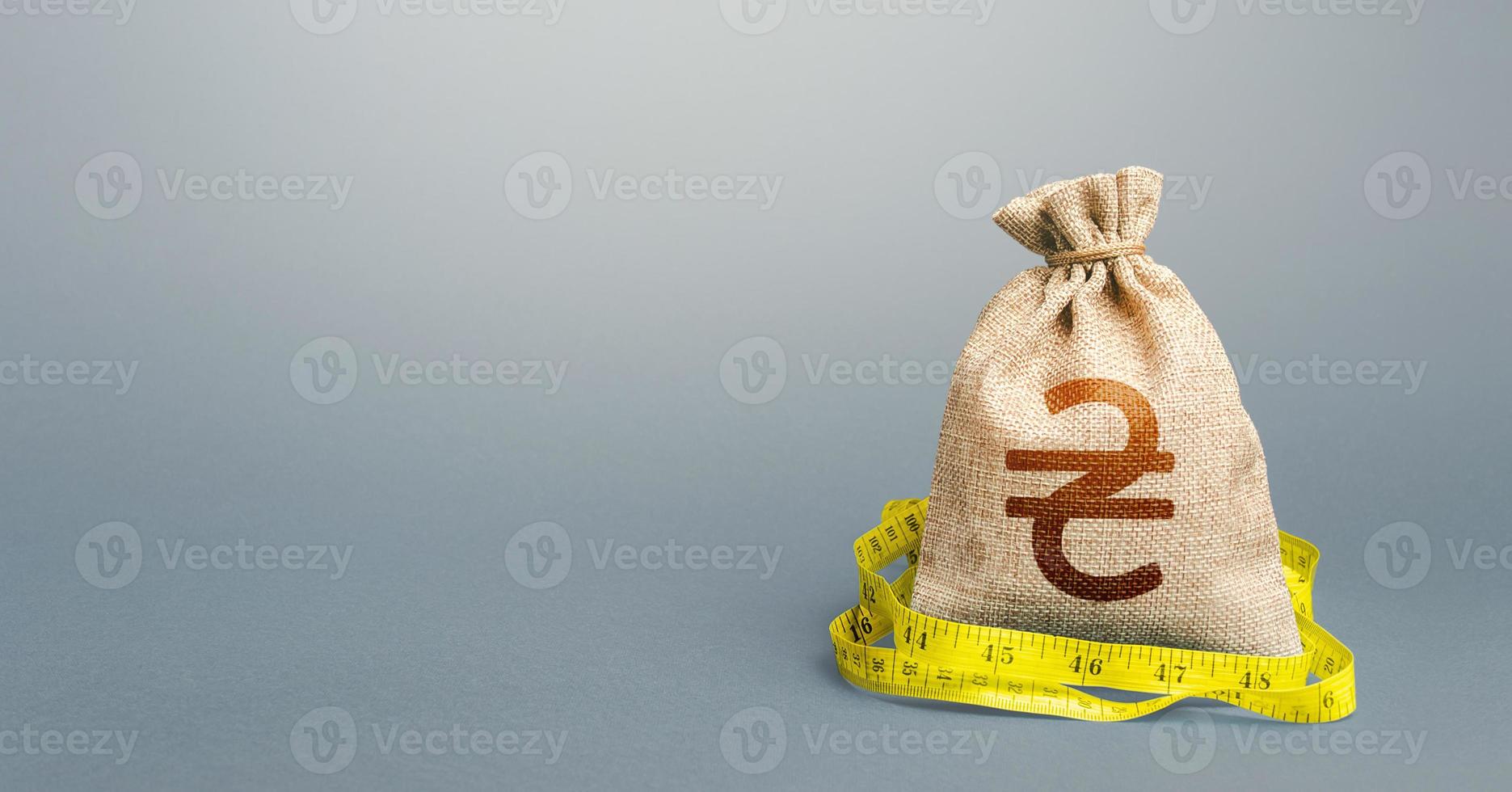 Ukrainian hryvnia money bag and measuring tape meter. Analysis of economic situation. Declaration of income, illegal. Assessment of capital. Formation and optimization of the budget, savings. photo