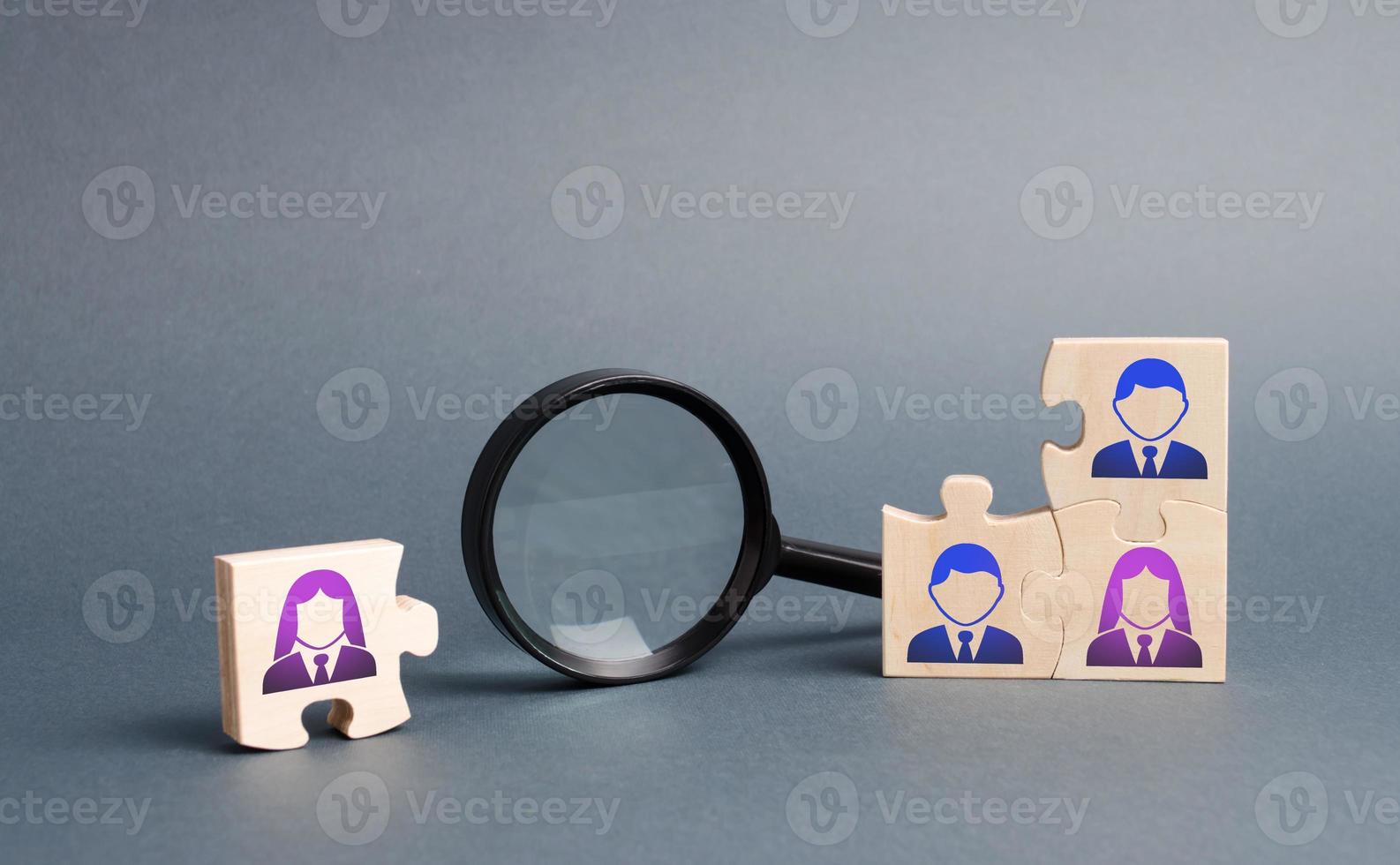 Unsorted team puzzle and magnifying glass. Search, recruitment staff, hiring leader. Lack of specialists in the labor market. Creating an efficient and productive business unit photo