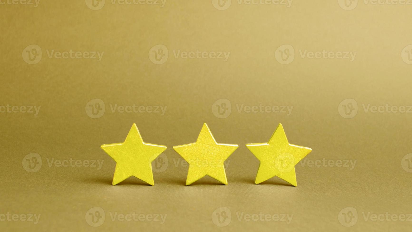 Three golden stars on a yellow background. Quality service, buyer choice. Success in business. The concept of rating and evaluation. The rating of the hotel, restaurant, mobile application. photo