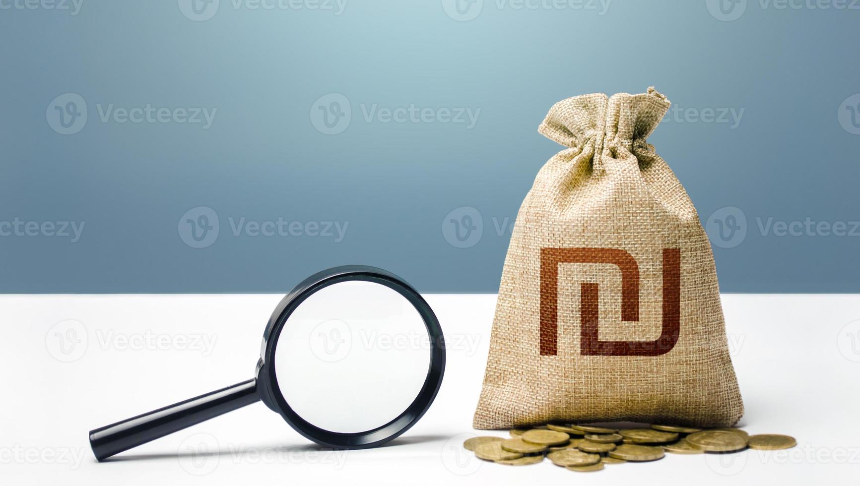 Israeli shekel money bag and magnifying glass. Financial audit and monitoring of suspicious capital and transactions. Search for beneficiaries. Budget check. Attracting investments financing. photo