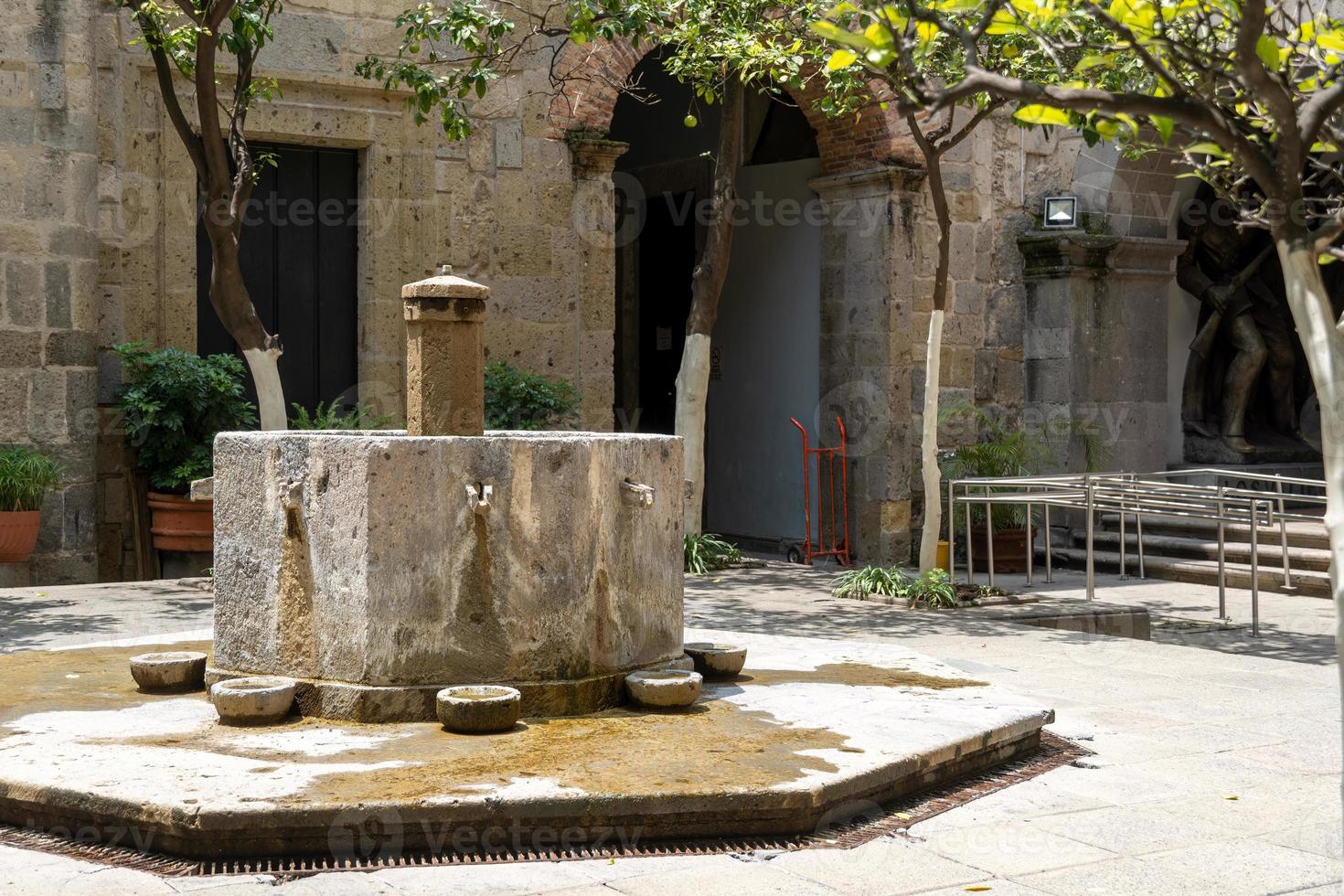 fountain inside old stone house surrounded by greenery, central courtyard, latin america photo