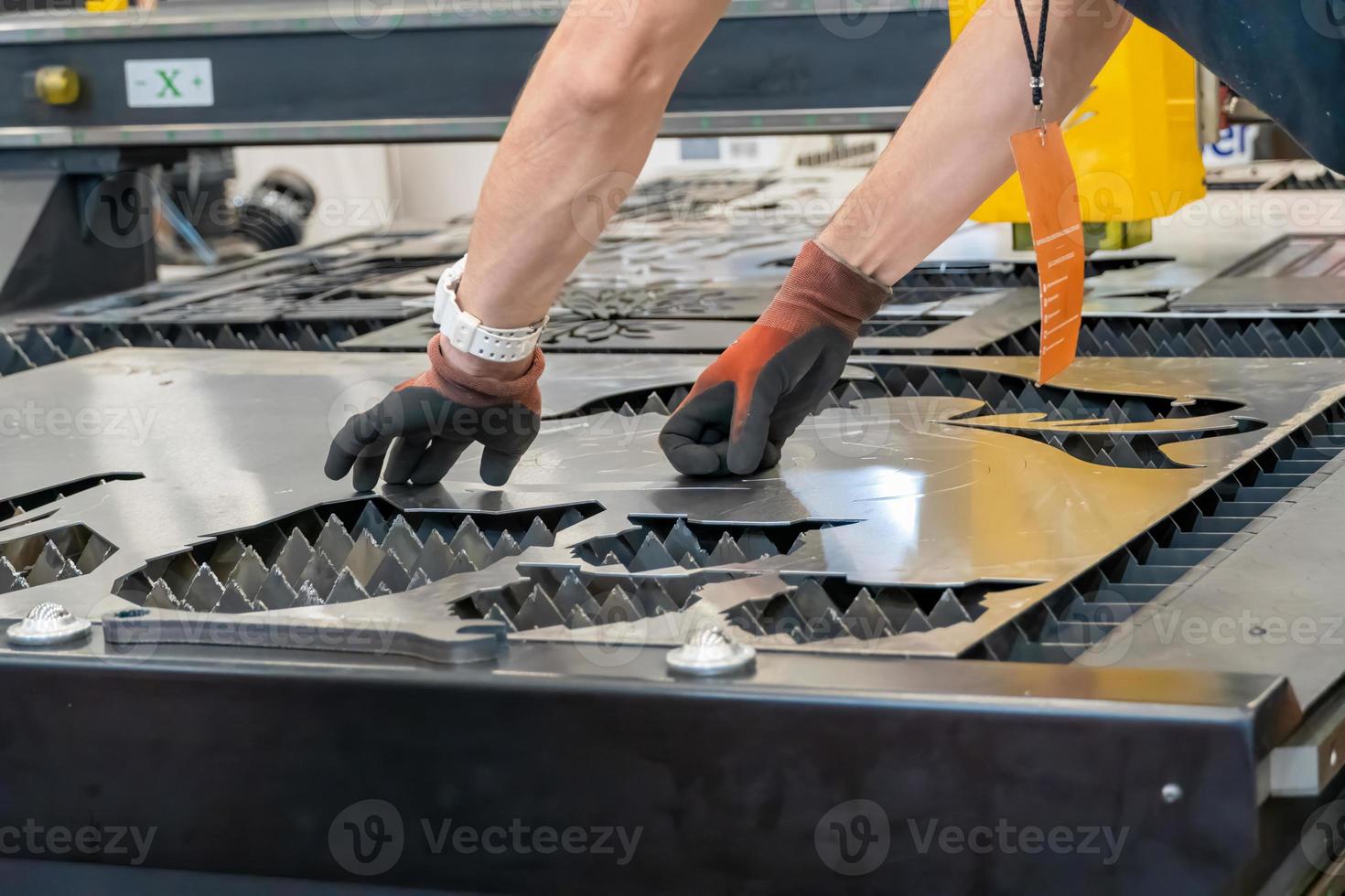 laser cutting machine, cutting wood sheets, while a man takes care of the process, latin america photo