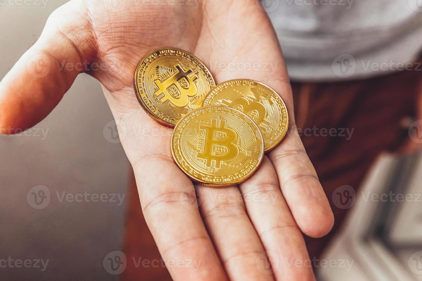 Man hand holding cryptocurrency golden bitcoin coin. Electronic virtual money for web banking and international network payment. Symbol of crypto virtual currency. Mining concept. photo