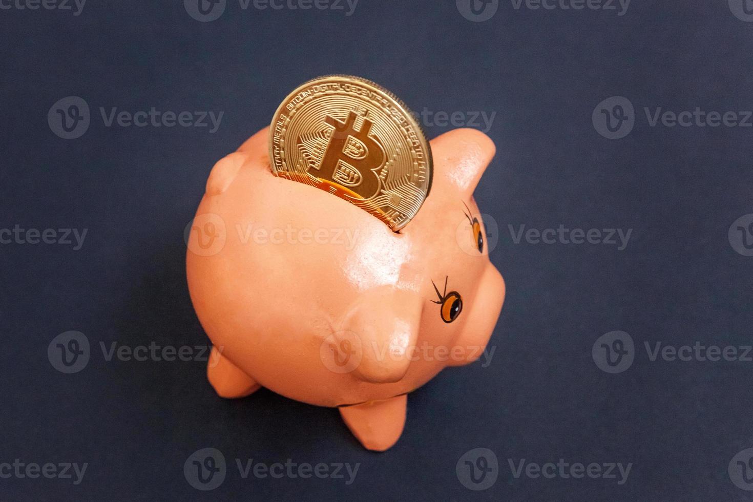 Piggy bank and golden bitcoin coin virtual money on black background. Cryptocurrency and saving concept. Electronic virtual money for web banking and international network payment photo