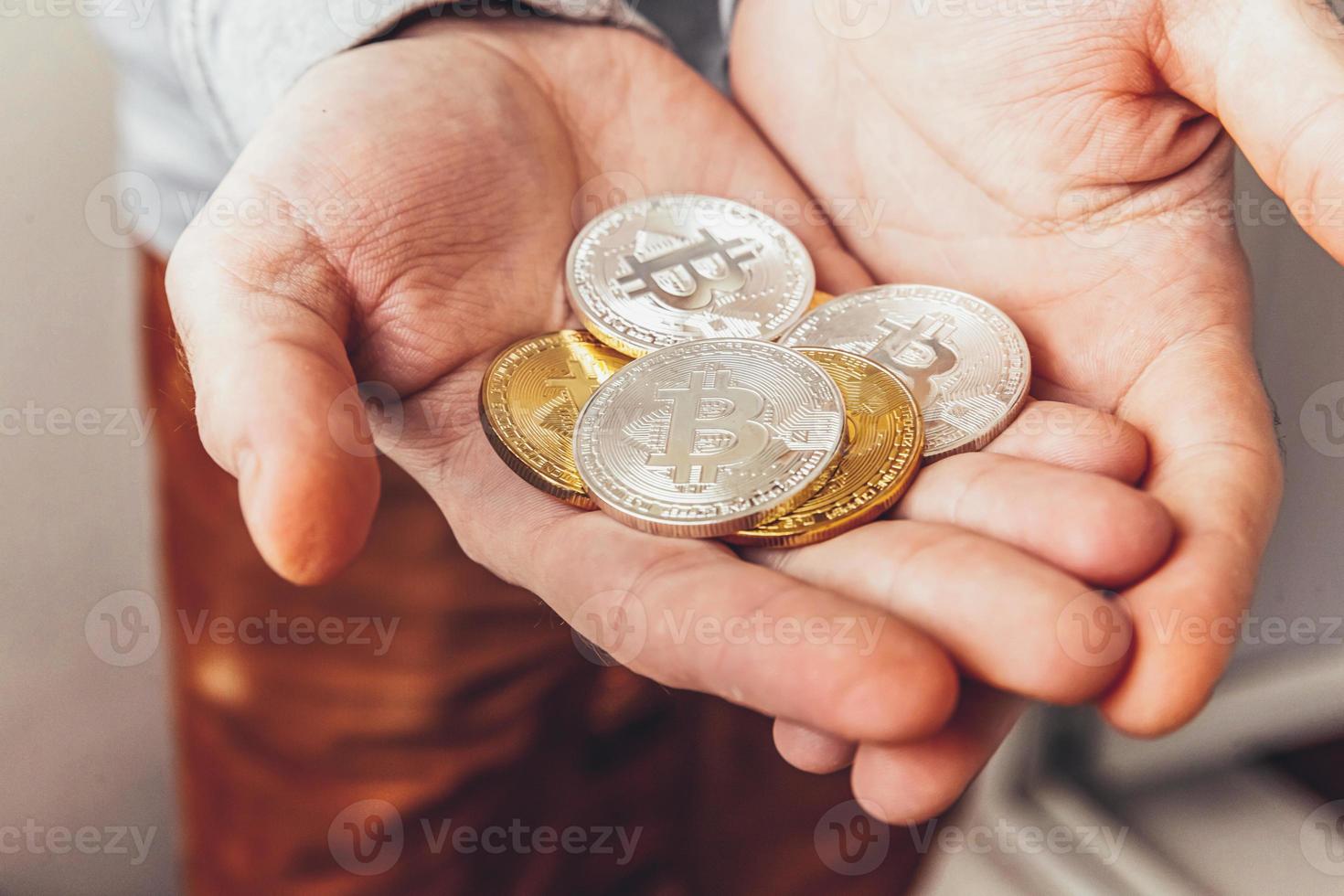 Man hand holding cryptocurrency golden and silver bitcoin coin. Electronic virtual money for web banking and international network payment. Symbol of crypto virtual currency. Mining concept. photo