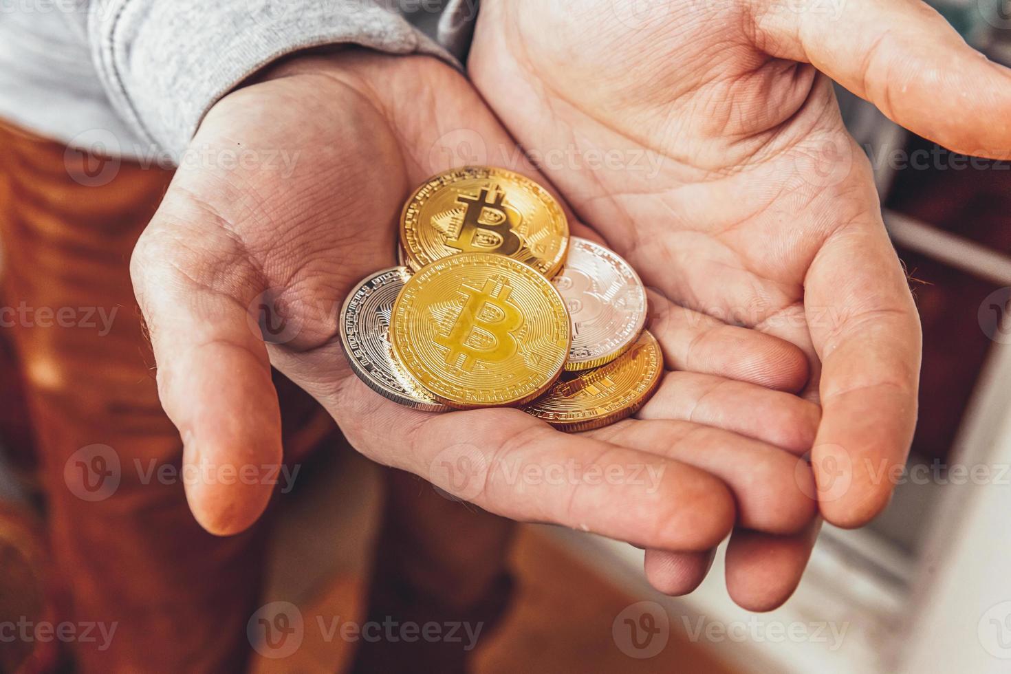 Man hand holding cryptocurrency golden and silver bitcoin coin. Electronic virtual money for web banking and international network payment. Symbol of crypto virtual currency. Mining concept. photo