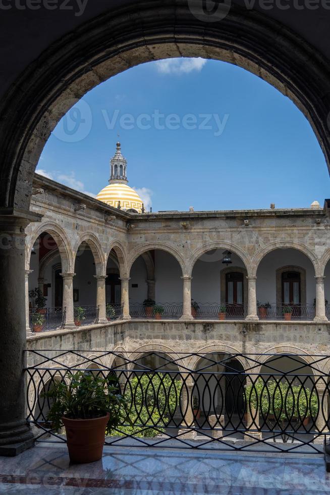 colonial architecture, arches surrounded by vegetation, play of light and shadows inside the space, natural materials photo