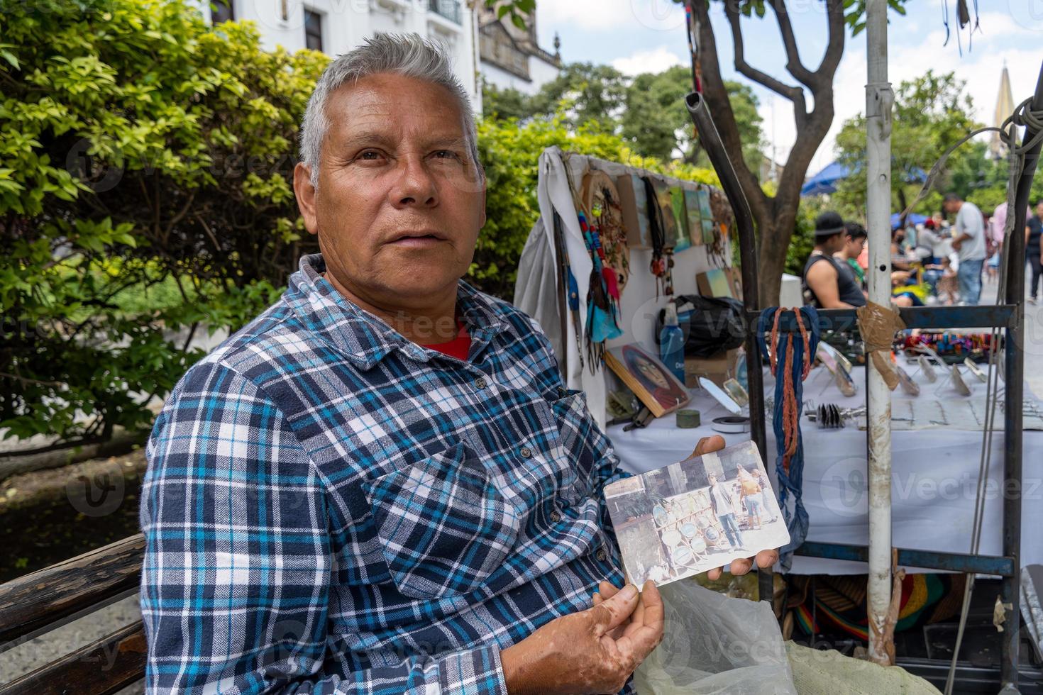 elderly street artist, brown latino man, painting pictures on the street, mexico photo