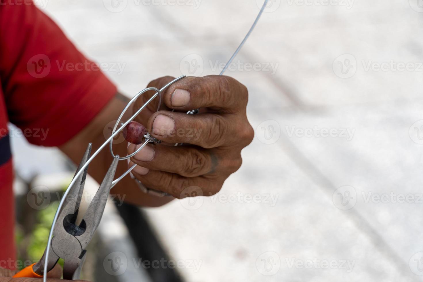 Anciano artesano haciendo figurillas de metal en la calle, México América Latina foto