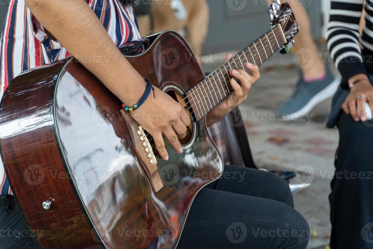 latina woman playing guitar in the street, young brunette woman, latin america photo