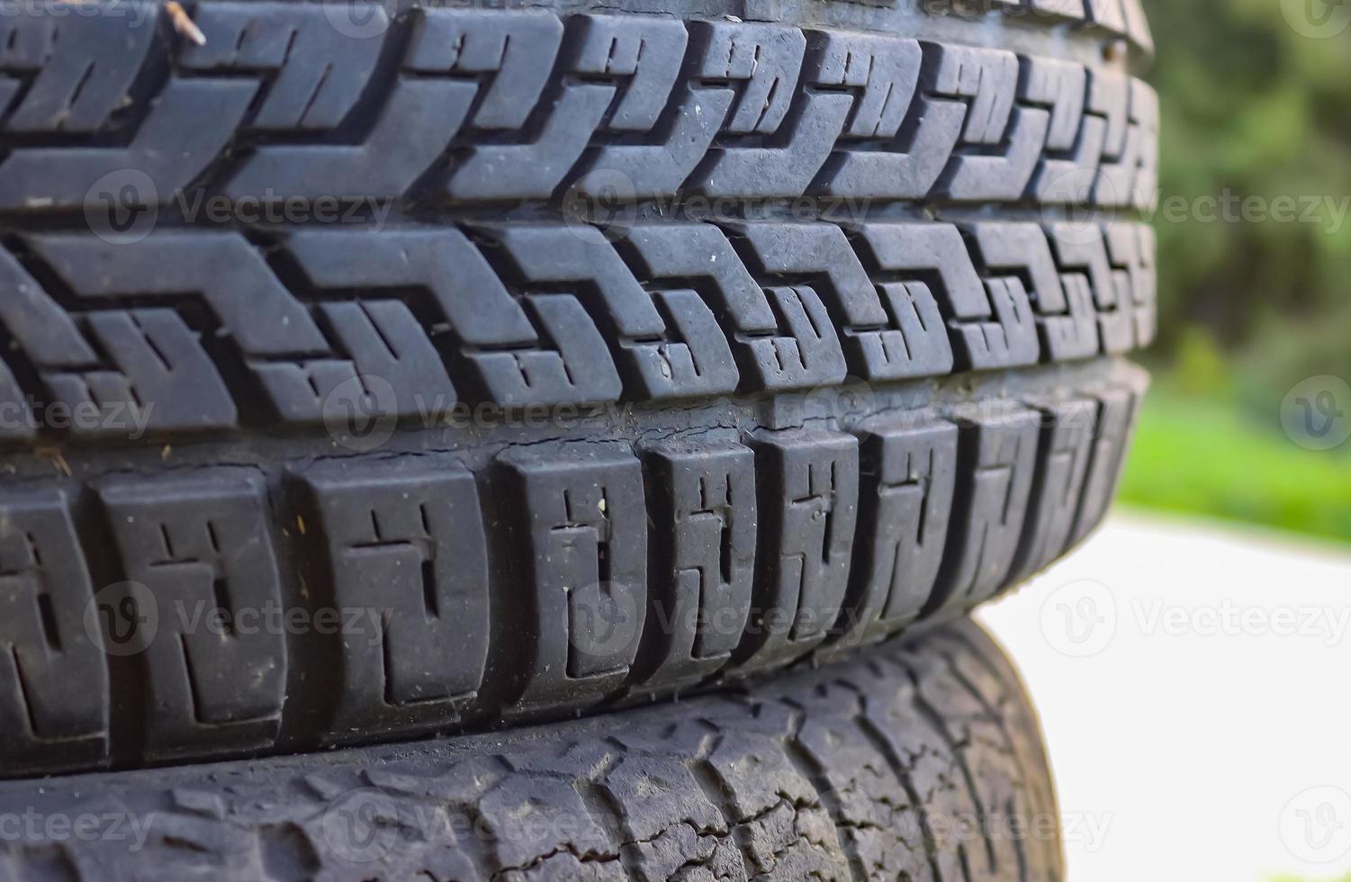 Damaged and worn old black tires on a stack. Damaged and worn old black tires on a stack. Tire tread problems. Solutions concept. Tire tread problems. photo